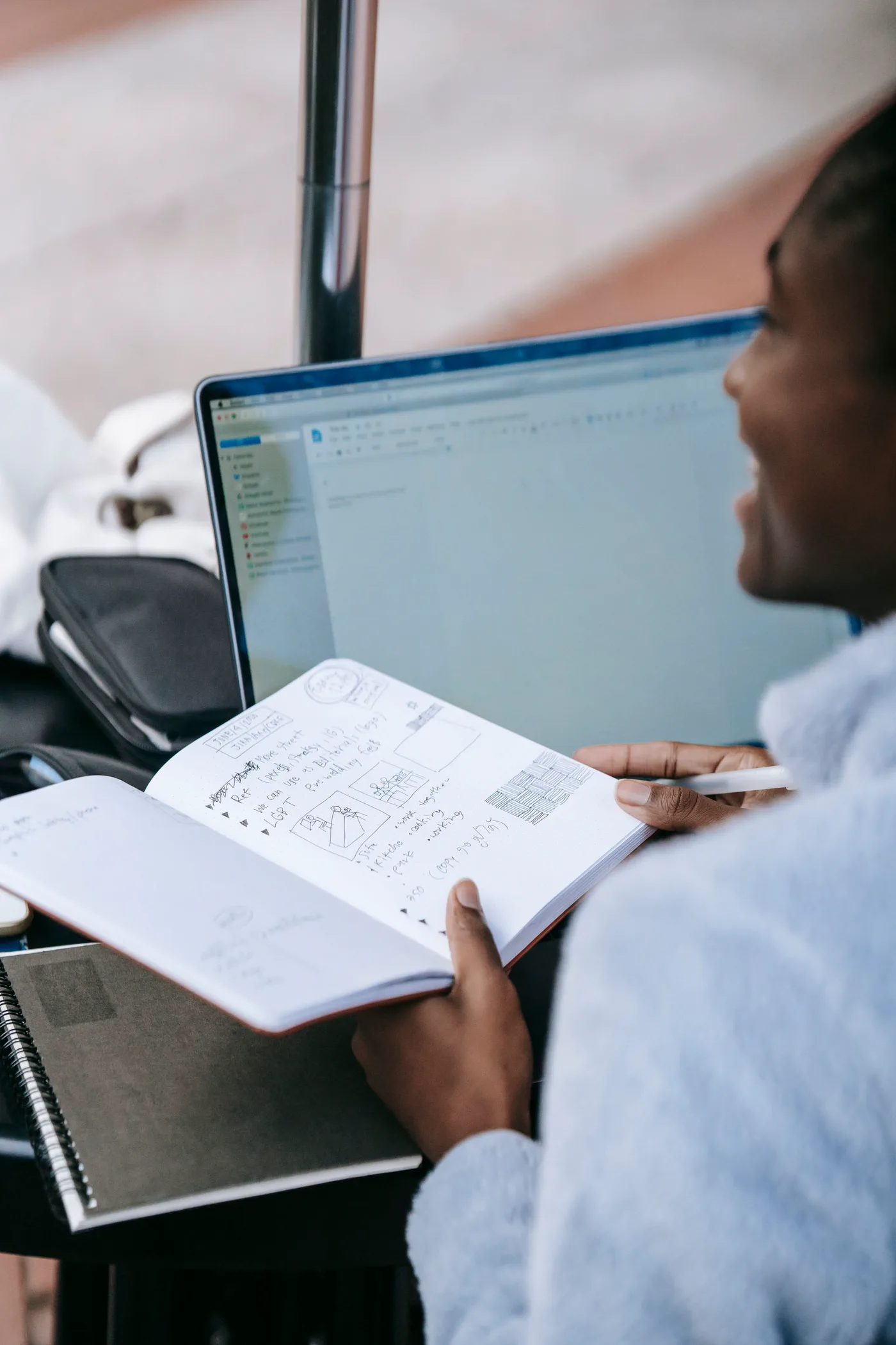A college student working with a laptop and notebook